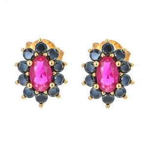 Detailed macro view of gold flower earrings with magenta center and black zircon stones