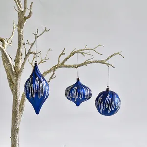 Detailed view of blue PVC Christmas ornaments with silver glitter waves on branch