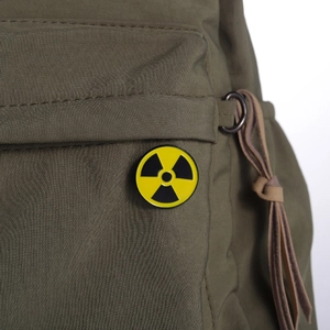 Tactical canvas backpack featuring a yellow radioactive symbol enamel lapel pin badge