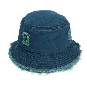 Close-up of distressed denim bucket hat with frayed edges and green fringe details