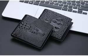 Detail of black crocodile pattern leather bi-fold wallets for men on a laptop background