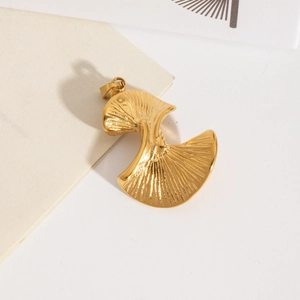 Vue détaillée d'un pendentif feuille de ginkgo dorée avec finition métal texturé