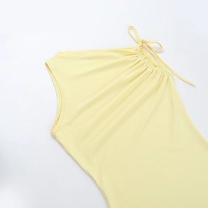 Detail eines hellgelben One-Shoulder-Kleides mit Schulterfalten und Schleifenelement