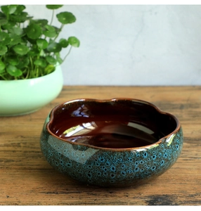 Close-up of a blue and brown glazed ceramic hydroponic bowl with irregular wavy edges