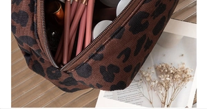 Detail of leopard print cosmetic bag showing spacious interior with makeup brushes