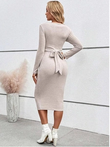 Detailed back view of beige knitted maternity dress featuring elegant waist bow tie