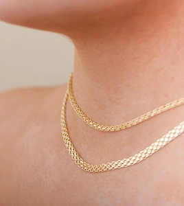 Gros plan d'un collier en maille plate en acier inoxydable plaqué or 18 carats