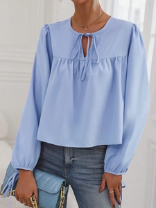 Elegante blusa azul claro con mangas abullonadas, cuello redondo con lazo y volantes