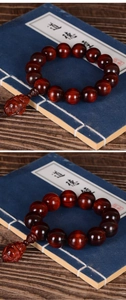 Detailed view of polished sandalwood beads and carved beast pendant on a classic book