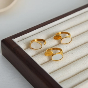 Three-piece set of 18k gold-plated open rings with white shell inlay on a jewelry box