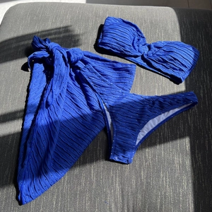 Royal blue three-piece bikini set with bandeau top and textured ruffled sarong skirt