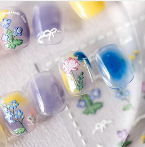 Close-up of frosted floral nail stickers featuring intricate 3D flower and mouse patterns