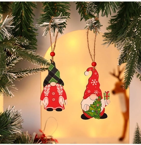 Detail of wooden gnome ornaments with snowflake hats hanging on festive pine branches