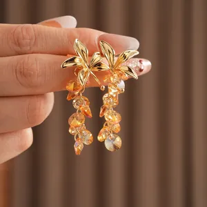 Vintage flower tassel earrings with amber crystal beads and golden leaves shown in hand