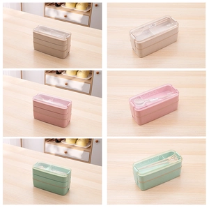 Detailed view of 750ml stackable lunch boxes in beige, pink, and green with cutlery inside