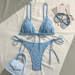 Detail of light blue bikini with waffle texture and floral bead accents on ties