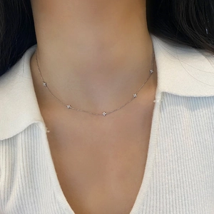 Elegant S925 sterling silver four-leaf star necklace with sparkling zircon on a female model