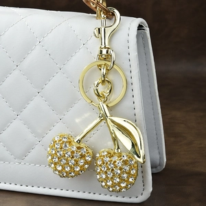 Sparkling cherry keychain with clear rhinestones on golden metal for luxury bags