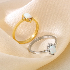Elegant gold and silver opal rings displayed on a luxurious champagne satin fabric