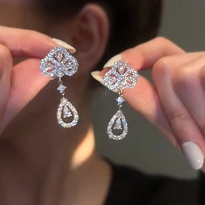 Détail de boucles d'oreilles fleurs en argent avec pendentifs en cristal de goutte d'eau