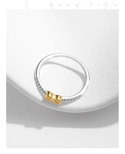 Macro view of s925 silver ring with golden infinity symbol and pavé diamond setting