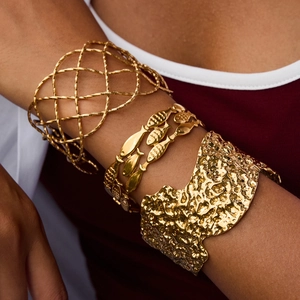 Three-piece gold stainless steel cuff bracelets featuring mesh, fish, and hammered textures
