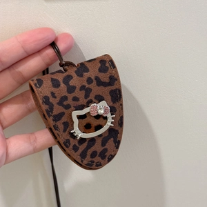 Detail of leopard print leather charm with metallic cat emblem and pink crystal bow