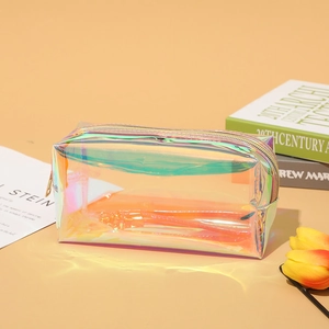 Holographic laser makeup bag with metal zipper on warm background with tulips