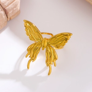 Detailed macro view of a large golden stainless steel bow butterfly ring with textures