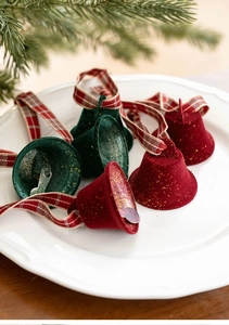Detail of red and green flocked Christmas bells with gold glitter and plaid ribbons