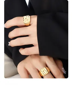Detail of gold square index ring with a hammered texture finish on model hand