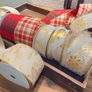 Assorted Christmas ribbons with plaid and snowflake prints on a vintage wooden tray