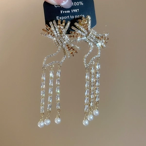 Close-up of tassel earrings with crystals and pearls on a premium display card