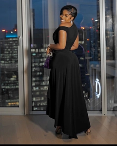 Detail of high-low hem and one-shoulder cut on a fitted black evening dress