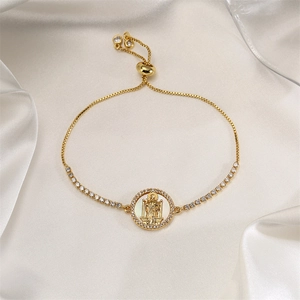 Detail van verstelbare gouden religieuze armband met San Judas-bedel in parelmoer en zirkoon