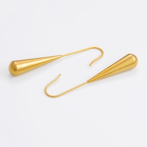Macro detail of golden hollow teardrop earrings with elegant curved hooks and polished finish