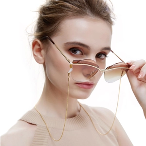 Detail shot of vintage cat-eye sunglasses with gold snake chain on model