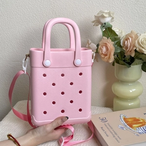 Detailed macro view of pink EVA tote bag featuring circular vents and woven shoulder strap