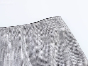 Gros plan détaillé sur le tissu à carreaux gris avec paillettes et bordure de taille noire
