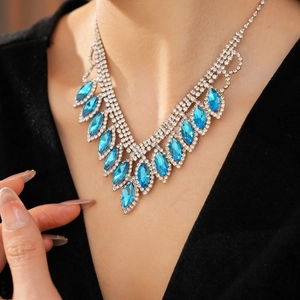 Close-up of elegant blue teardrop crystal necklace with tassels on a female model