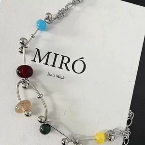 Handmade necklace with mixed colorful beads and metal spheres on a minimalist silver chain