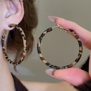 Leopard print hoop earrings with golden metal finish for a retro vintage aesthetic