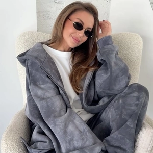 Détail d'un ensemble jogging tie-dye gris à texture marbrée posé sur un fauteuil