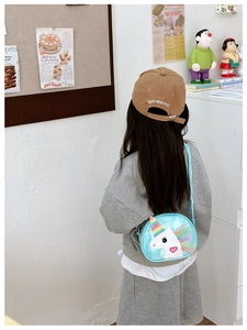 Little girl wearing a light blue sparkly unicorn crossbody bag with rainbow hair