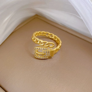 Detailed macro view of a gold chain belt ring with inlaid diamonds in a jewelry box