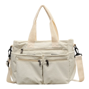 Off-white corduroy tote bag with multiple front zip pockets and adjustable strap
