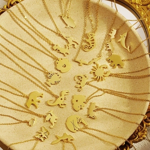 Gold stainless steel animal silhouette necklaces on a ceramic plate for women