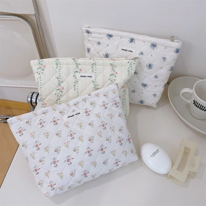 Detail of floral quilted cotton makeup bags with diamond stitching and woven labels