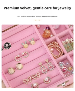 Close-up of pink velvet jewelry box interior with rings and earrings storage slots