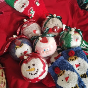Detailed close-up of festive coral fleece Christmas socks packed in clear gift spheres